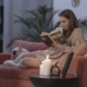 Indoor air - lady sitting reading with candle on side table and dog on sofa